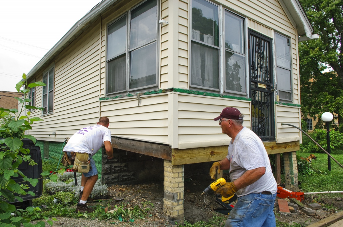 Handyman Ministries workers shore up a porch.