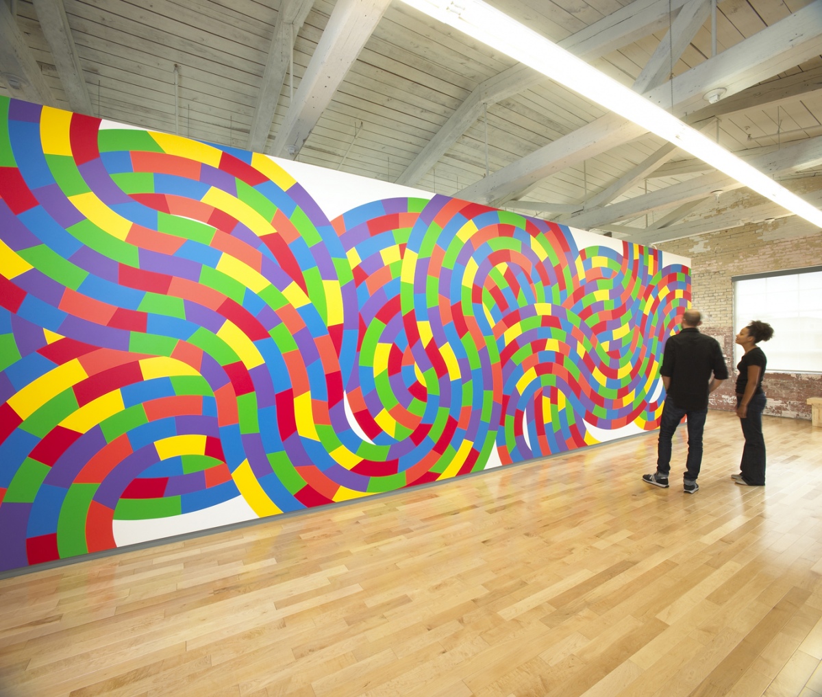 Visitors examine one of the large-scale wall drawings from “Sol LeWitt: A Wall Drawing Retrospective” at the Massachusetts Museum of Contemporary Art, MassMoCA.